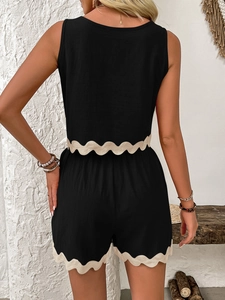 Detail view showing scalloped beige edges on black linen two-piece tank top and shorts
