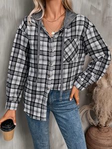 Detail of oversized plaid shirt with grey hood and drawstring in an urban industrial setting