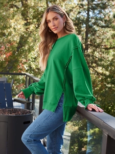 Detail mit Seitenschlitz und Außennähten an einem grünen Oversized-Baumwoll-Sweatshirt