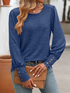 Detail of navy knit shirt showing puff sleeves and decorative brown buttons at cuffs