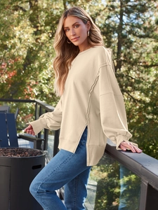 Detail eines beige Sweatshirts mit Seitenschlitz und sichtbaren Nahtdetails