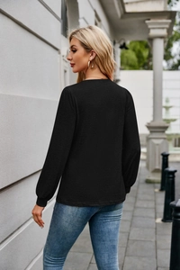 Detailed back view of women's black long sleeve top showing fine horizontal fabric texture