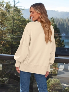 Detail eines beigen Oversize-Sweatshirts mit überschnittenen Schultern und Rippbündchen