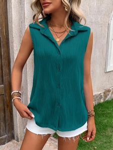 Detail shot of green sleeveless shirt with vertical pleat texture and classic button collar