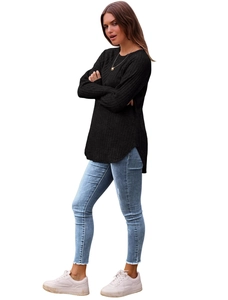 Dettaglio del top nero in maglia a coste con orlo curvo e jeans in denim con frange