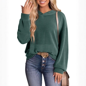 Deep green hooded waffle knit sweater paired with blue high-waist buttoned jeans