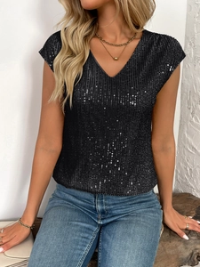 Détail des paillettes noires scintillantes sur le haut à col en V et manches courtes