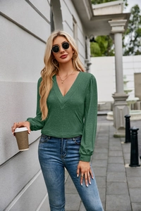Detail of elegant V-neck dark green long sleeve top with pleated texture and soft fabric
