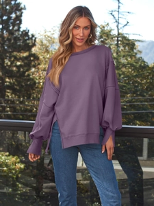 Outdoor-Aufnahme eines locker sitzenden lila Sweatshirts mit Seitenschlitzen und Rippbündchen