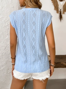 Detail of light blue knit top featuring intricate hollow diamond weave patterns on the back