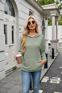 Detail of light green ribbed knit hoodie featuring drawstring hood and kangaroo pocket