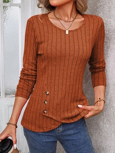 Detail of slim fit ribbed knit top in brick red with decorative buttons on asymmetric hem