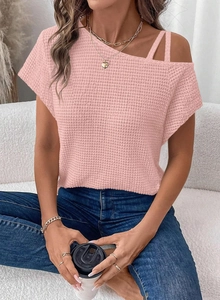 Detail of light pink waffle knit top showing off-the-shoulder cut and textured fabric
