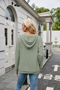 Detail of ribbed knit texture on sage green oversized hoodie with a back view and hood