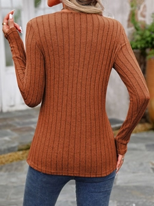 Close-up of caramel ribbed knit fabric texture on a long sleeve slim fit crewneck top