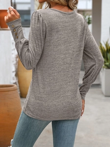 Detailed view of button sleeve cuff and heather grey knit fabric on long sleeve shirt