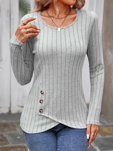 Detail of grey ribbed knit top featuring asymmetrical hem and decorative wooden buttons