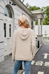 Detail of oatmeal ribbed knit hoodie with drop shoulder and textured fabric finish