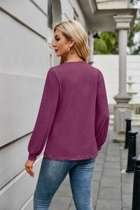 Detail of dark purple long sleeve top featuring elastic lantern cuffs and knit texture