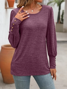 Detail view of burgundy knit top with puff sleeves and decorative buttons on cuffs