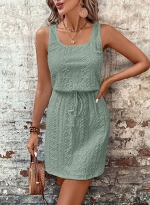 Detail of sage green lace dress showing intricate floral cutouts and drawstring waist