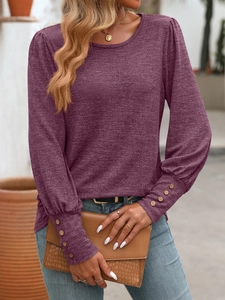 Detail of waffle knit fabric and wooden buttons on the puff sleeve cuff of purple top