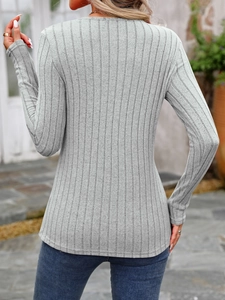 Close-up of light gray ribbed knit fabric texture on a slim-fit crewneck long sleeve top