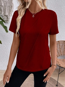 Detailed view of women's burgundy T-shirt with elegant diagonal pleats and round neckline