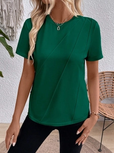 Detailed close-up of dark green T-shirt featuring elegant diagonal pleat stitching texture