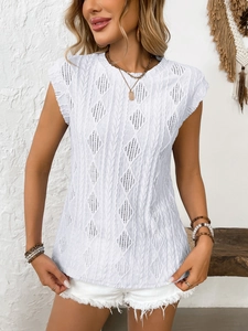 Detailed close-up of white knitted top with hollow diamond patterns and vertical cables