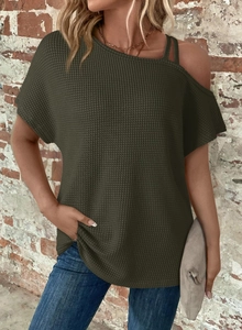 Detail of army green waffle knit top showing cold shoulder design and textured fabric