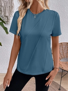Detailed close-up of blue t-shirt featuring asymmetric diagonal pleats and draped fabric