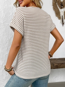 Detail of khaki and white striped knit top with rolled sleeves and texture on a female model