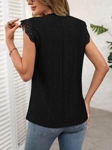 Detail of elegant black sleeveless top showing intricate floral lace and eyelet embroidery