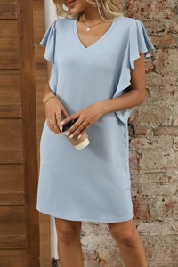 Detail of light blue V-neck dress showing waffle knit texture and ruffle flutter sleeves