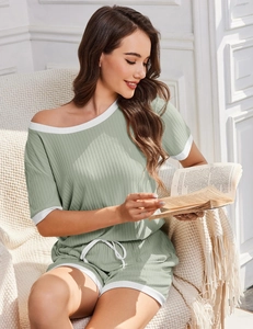 Detail der gerippten salbeigrünen Loungewear mit weißem Kontrastrand und Kordelzug