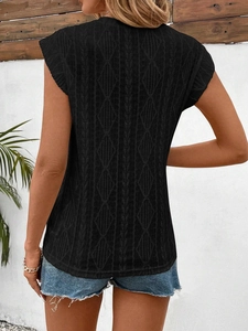 Close-up of black sleeveless knit top showing intricate diamond jacquard and hollow textures