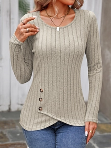Detail of ribbed knit top with asymmetrical hem and decorative brown side buttons