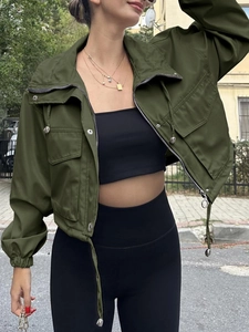 Detail of dark green cropped utility jacket with silver zipper and large flap pockets