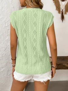 Detail view of light green knit sleeveless top with diamond hollow and cable patterns