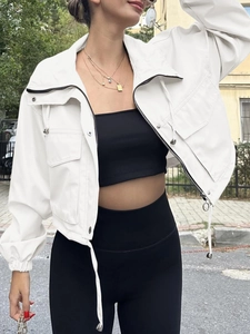 Close-up detail of white short jacket showing zipper, drawstring collar and cargo pockets