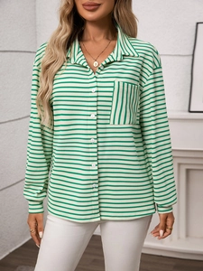 Macro detail of the green striped knit shirt fabric showing front pocket and white buttons