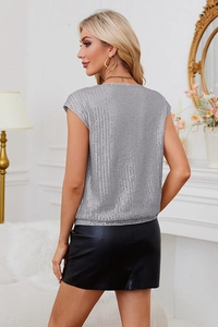 Gros plan du débardeur à paillettes argentées avec rayures verticales et jupe en cuir chic