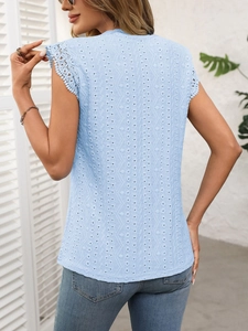 Macro detail of eyelet fabric and crochet lace trim on the light blue summer top