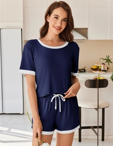 Detail eines dunkelblauen Pyjama-Sets mit Rippenstrick, weißer Paspelierung und Tunnelzug