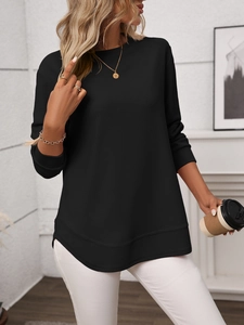Detailed macro view of the black waffle knit texture and curved hemline on a casual top