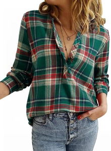 Detail of plaid V-neck shirt featuring button closure and classic checkered pattern fabric