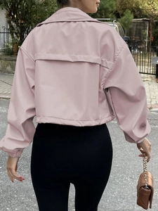 Detail of pink short jacket featuring drop shoulders and layered back windbreaker flap