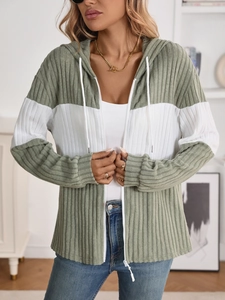 Close-up of sage green and white color-block knit cardigan with ribbed texture and zipper