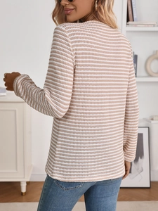 Side-back view of woman wearing apricot and white striped knit long sleeve top